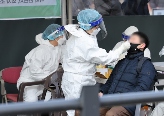 17일 오전 서울 중구 서울역 임시 선별검사소에서 시민들이 신속항원검사를 받고 있다. <연합뉴스>